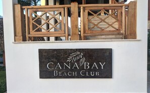 A wooden gate with a sign that reads "CanaBay Beach Club". - Coral Bay by DR Collection (Punta Cana)