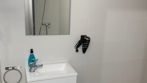 A bathroom with a white sink, a mirror, a towel ring, and a shower. - Home SEA&DREAMS OldTown IV (Calp)