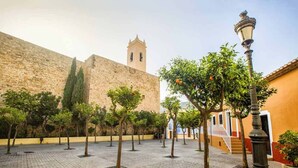A courtyard with a stone wall, trees, and a lamp post. - Home SEA&DREAMS OldTown IV (Calp)