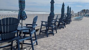 A beachside seating area with chairs and umbrellas, overlooking the ocean.