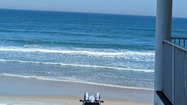 A beach view with a building and a lifeguard tower.