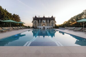 Una piscina al aire libre de temporada, sombrillas