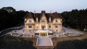 A large, multi-story house with a symmetrical facade, multiple chimneys, and a central entrance with a small porch. - Maison Douce Epoque - Deauville (Benerville-sur-Mer)