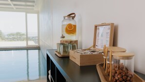 A kitchen counter with a water dispenser, a wooden box, and a tray with nuts. - Maison Douce Epoque - Deauville (Benerville-sur-Mer)