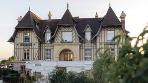 A large, historic building with multiple gabled roofs and a central entrance. - Maison Douce Epoque - Deauville (Benerville-sur-Mer)