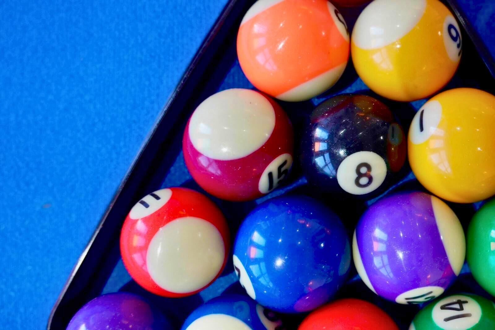A close-up of a pool table with colorful billiard balls.