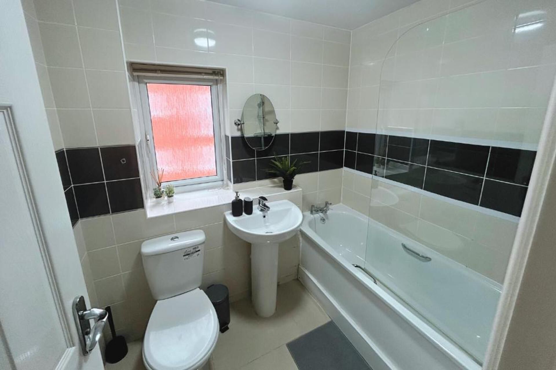 A bathroom with a toilet, sink, and bathtub.