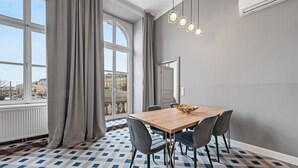 Een moderne eetruimte met een geruite vloer, een houten tafel en grijze stoelen.