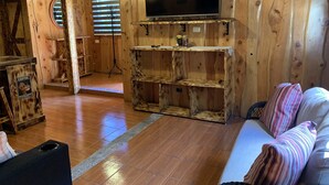 A wooden interior with a TV on a shelf, a sofa, and a coffee station. - The perfect escape to reconnect with nature and yourself.  (Alajuela)