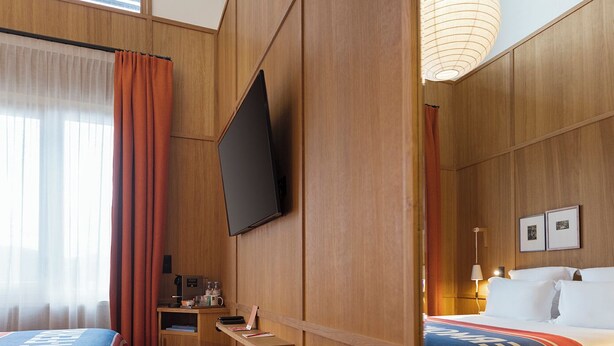A hotel room with a bed, a desk, a television, and a mirror. - GRAND MESS Clermont-Ferrand (Clermont-Ferrand)