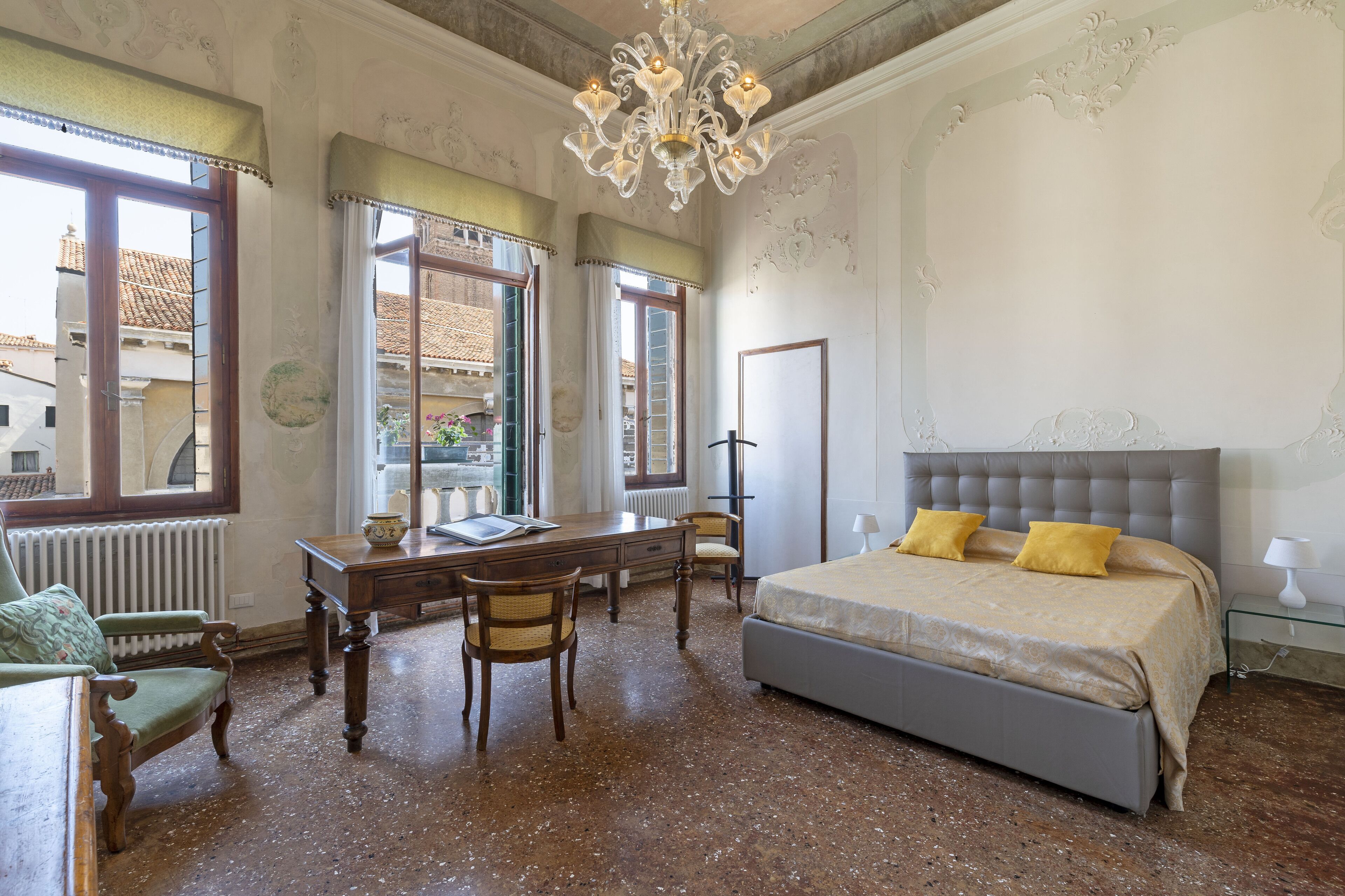 A bedroom with a large bed, a desk, and a chair.