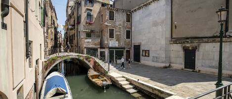 Un canal estrecho con barcos, un puente y edificios a lo largo del agua.