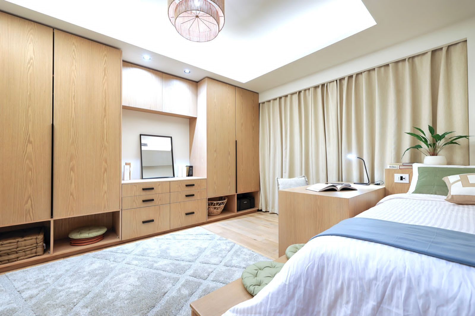 Une chambre moderne avec un grand lit, une armoire intégrée, une table de chevet et une lucarne.