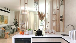 A modern kitchen with a built-in dishwasher, wooden cabinets, and a countertop with various kitchen items. - VESTA - Luxury APT - 3BR - La Mirada (New Cairo City)