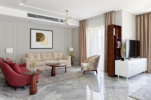 A modern living room with a sofa, armchairs, a coffee table, a TV stand, and a bookshelf. - VESTA - Luxury Villa - 4BR - CFC (II) (New Cairo City)