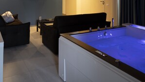 A modern living room with a pool table, a sofa, and a flat-screen TV.