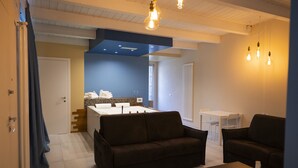 A modern living room with a sofa, a coffee table, and a dining area with a table and chairs.