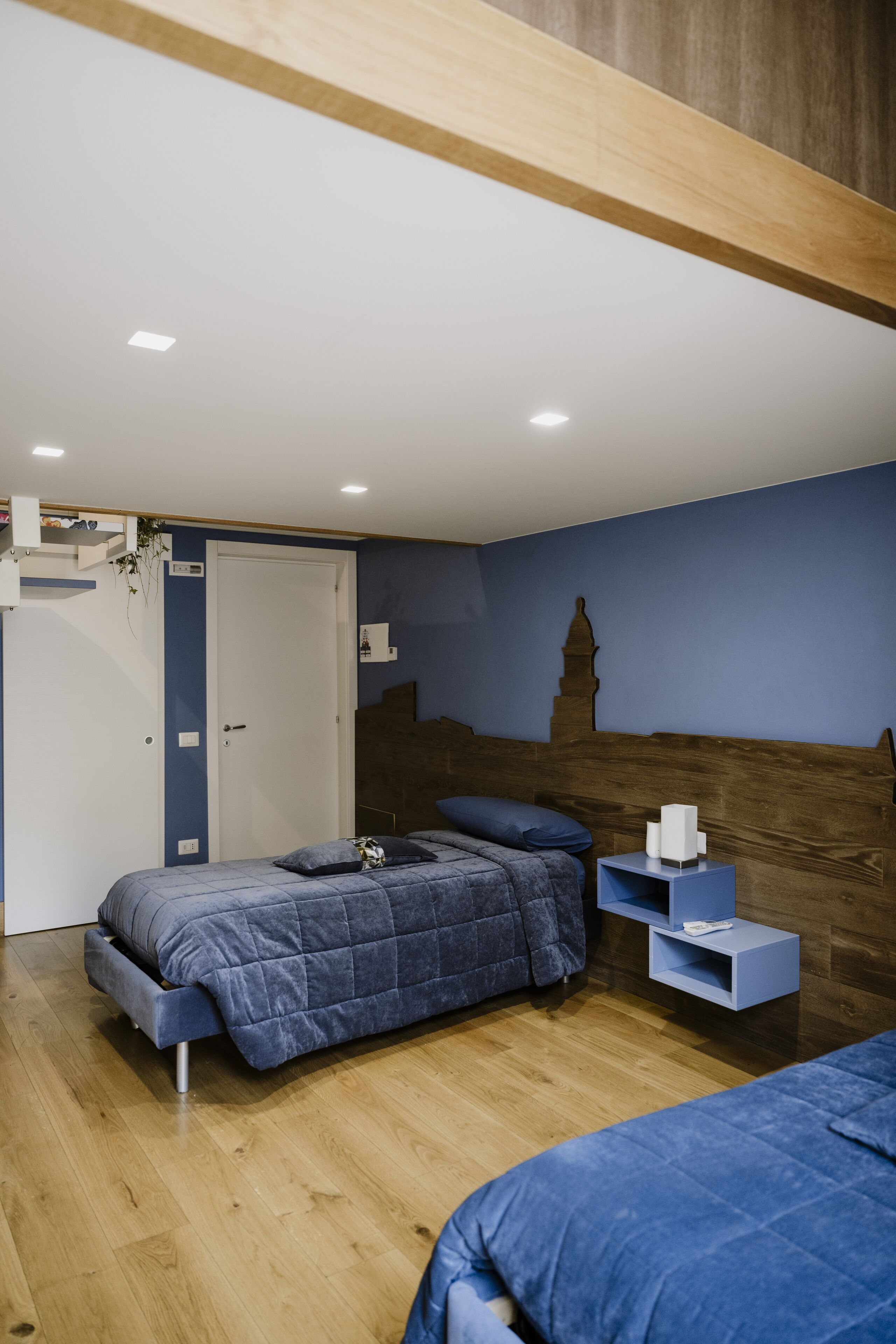 A bedroom with a bed, a nightstand, a dresser, and a door.