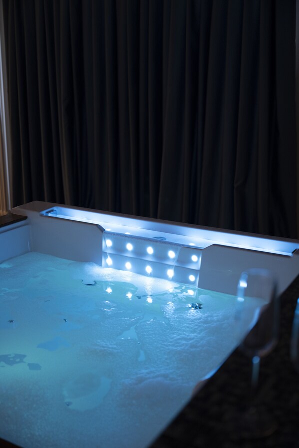 A room with a vanity mirror and a lighted vanity area.