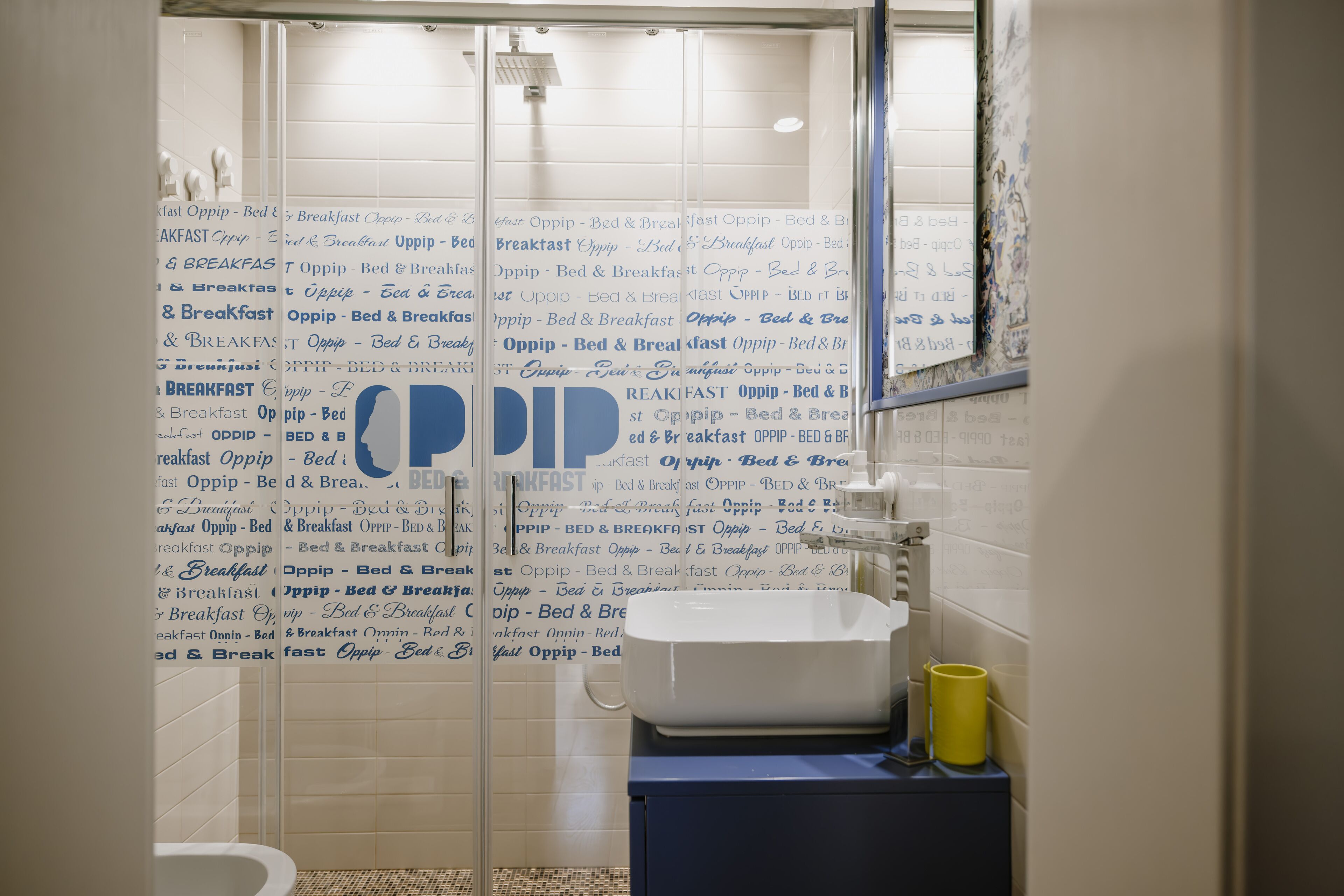 Un baño con cabina de ducha de vidrio, un lavamanos y un espejo.