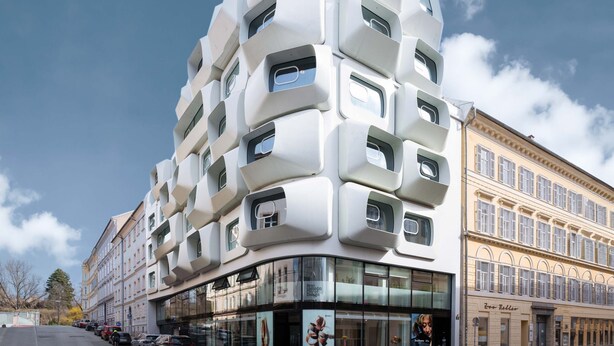 Un bâtiment moderne doté d’une façade géométrique originale et de grandes fenêtres.