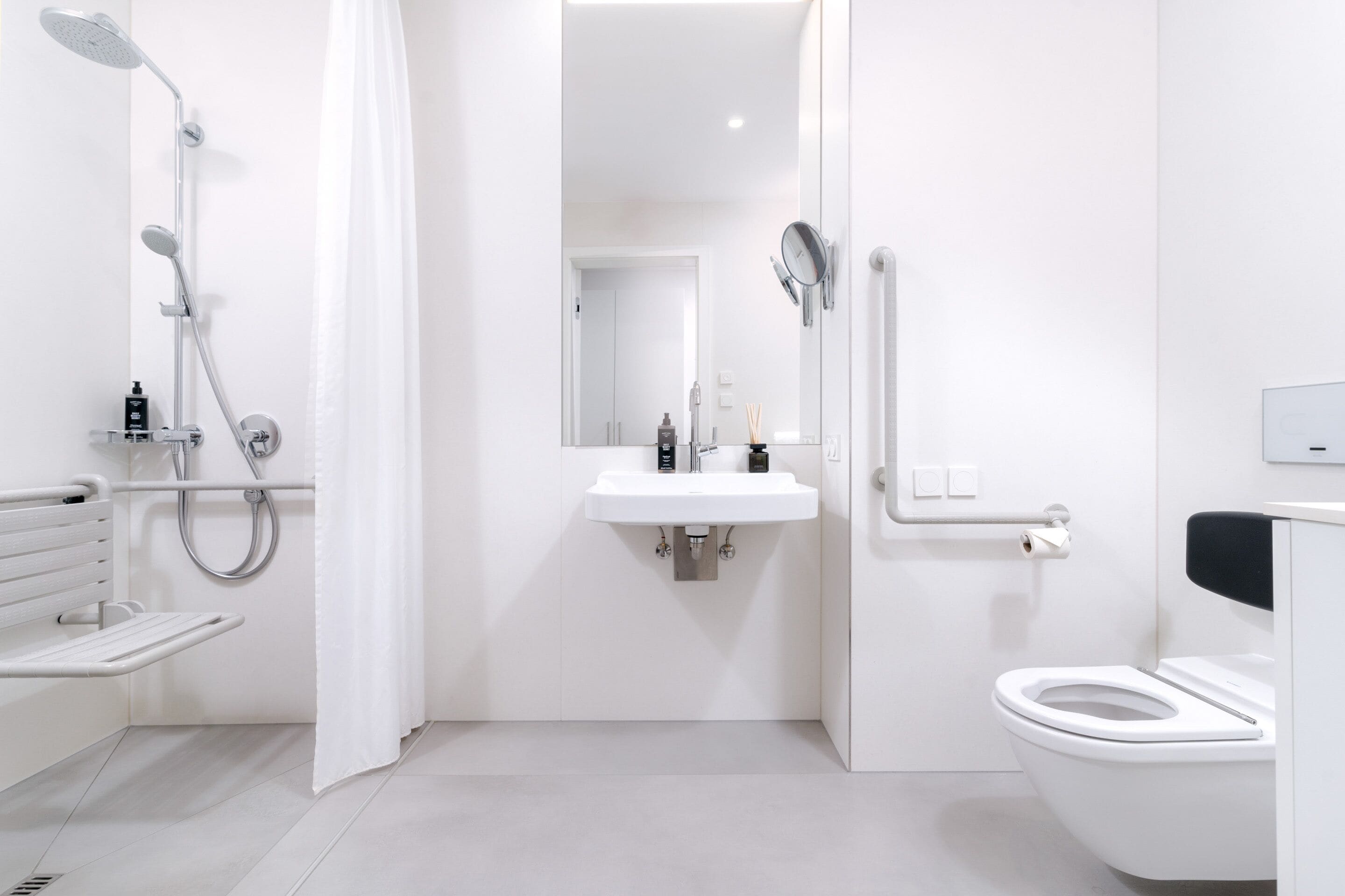 Une salle de bain moderne équipée d’une douche, de toilettes et d’un lavabo.