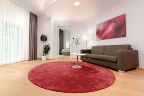 One - Bedroom Deluxe Suite | Living area | 49-inch flat-screen TV with cable channels - Limehome Graz - Argos by Zaha Hadid (Graz)