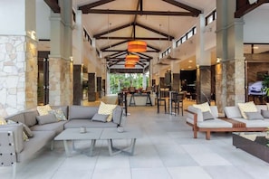 Un'ampia hall con soffitto alto, colonne in pietra e arredi moderni.