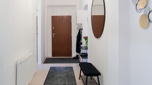 Ein Flur mit einer Holztür, einer Bank, einem Spiegel und einer Wand mit dekorativen Tellern.