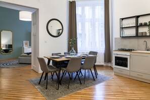 Een moderne keuken met een eethoek, voorzien van een houten tafel, stoelen en een ingebouwde oven.