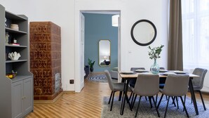 Ein moderner Essbereich mit Holzboden, einem runden Tisch mit Stühlen, einem Spiegel und einem Blumentopf.