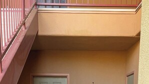 A building entrance with a door marked '121A' and a red metal staircase to the left.