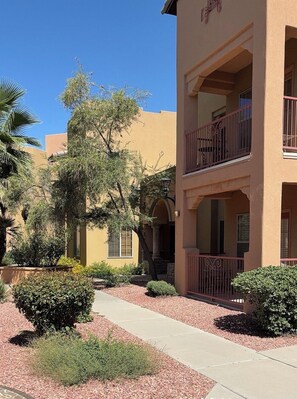 Un patio con un camino, rodeado de edificios con balcones y ventanas arqueadas.