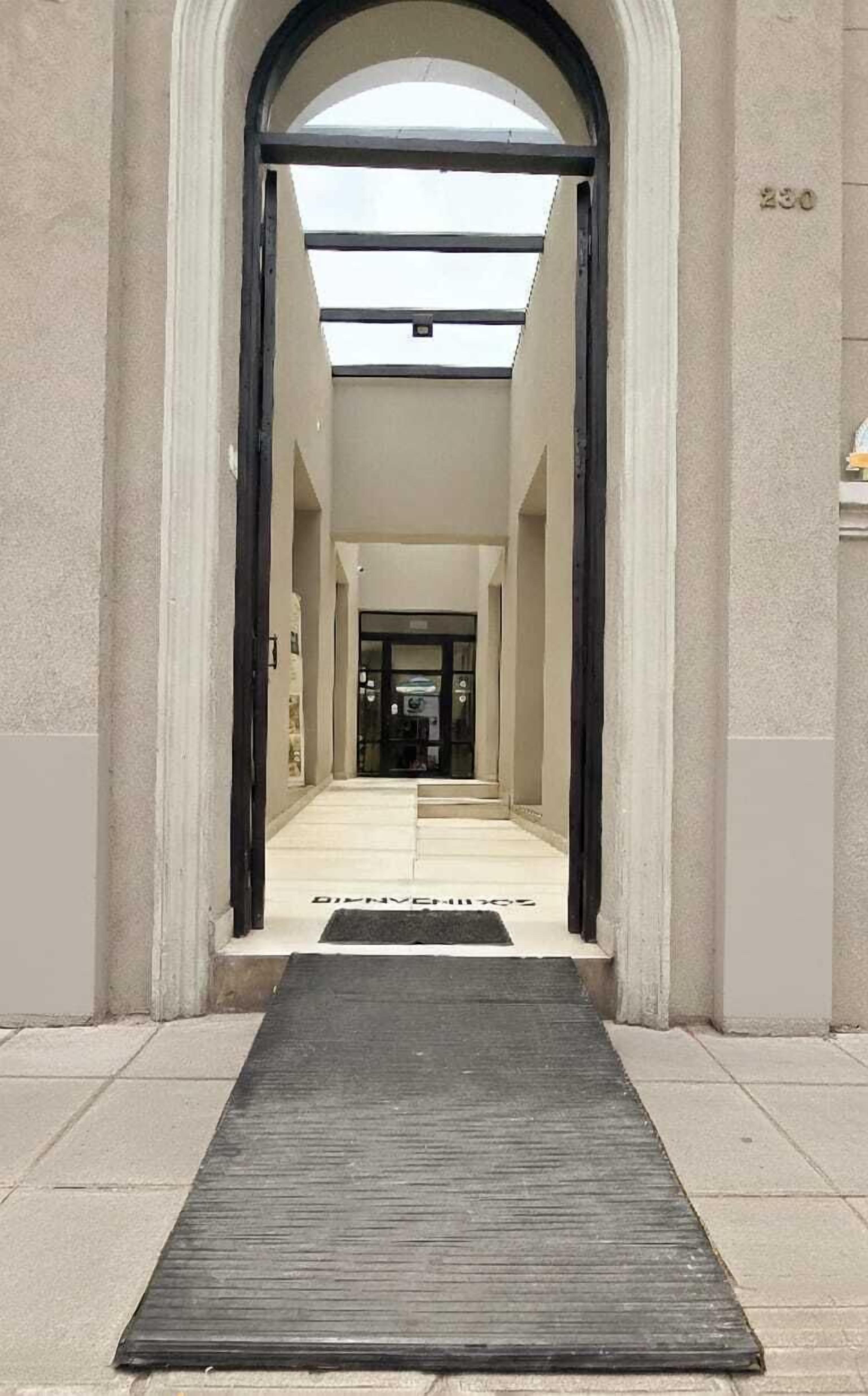 A corridor with a black mat leading to a door labeled "DINING ROOM."