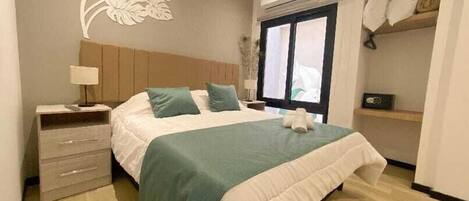 A neatly arranged bedroom with a bed, bedside table, lamp, and a wall decoration.