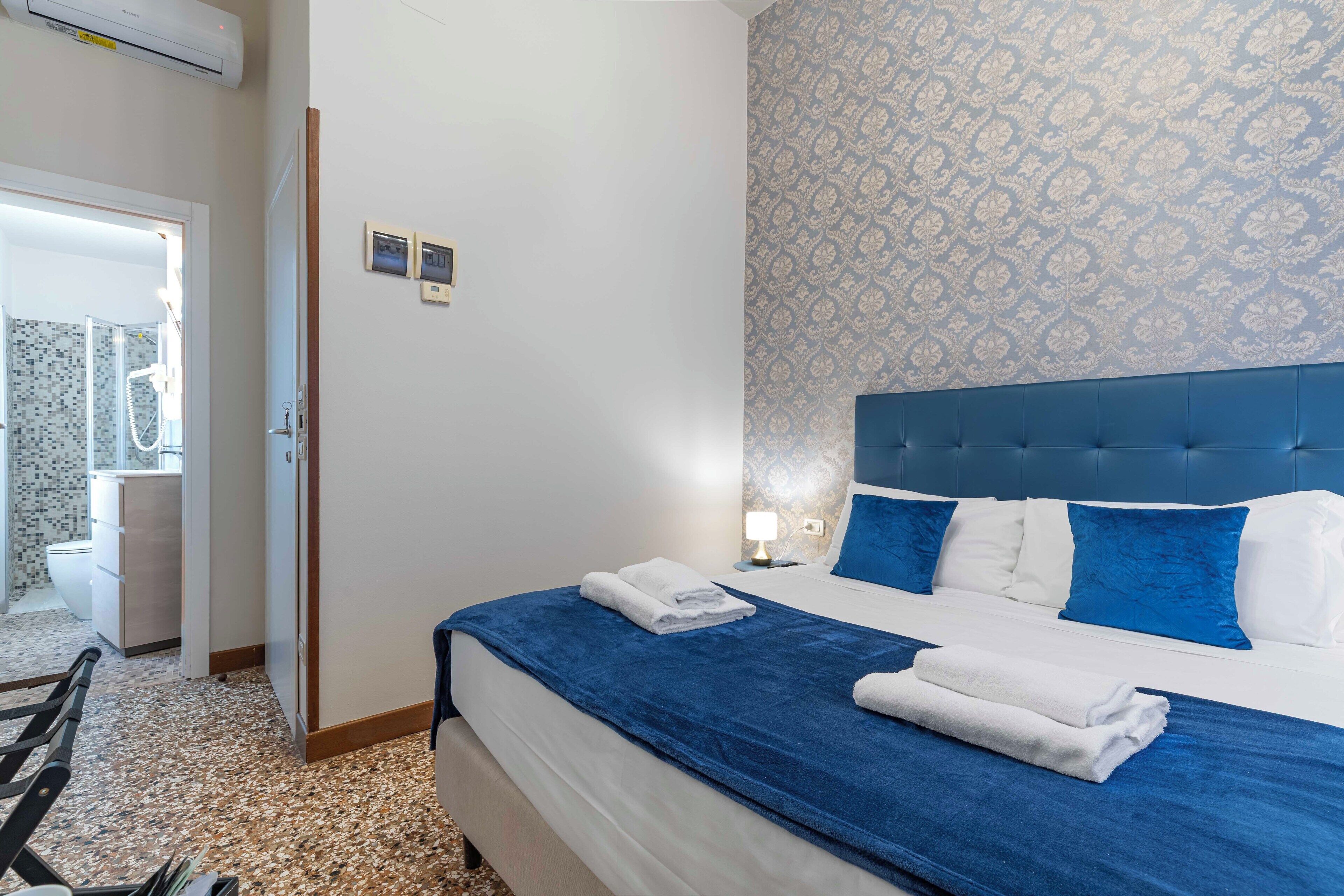 Une chambre d’hôtel comprenant un lit, une salle de bain et une porte donnant sur une autre pièce.