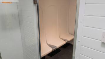 A restroom with three white sinks and a black floor.