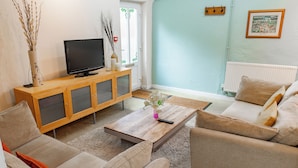 A living room with a TV, sofa, and coffee table. - 2 Bed Barn conversion (Tibenham)