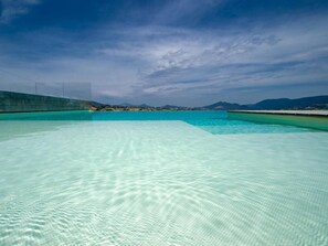 A clear, expansive swimming pool with a view of distant mountains and a clear sky. - Serre Alte Landscape luxury Rooms (Matelica)