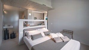 Een moderne slaapkamer met een groot bed, nachtkastjes, een spiegel en uitzicht op de omgeving.