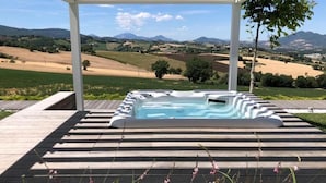 Een hottub onder een pergola met uitzicht op het landschap.