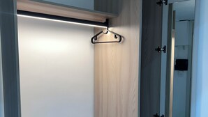 A walk-in closet with a wooden finish, a hanging rod, and a mirror. - Gabry's House-Apartment equipped with all amenities in the center of Naples. (Napoli)