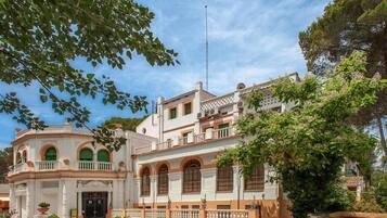 A historic building with a symmetrical facade, arched windows, and a central entrance.