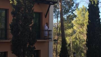 A building with a balcony, trees, and a clear sky.