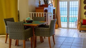 Un espace repas comprenant une table et des chaises, un meuble décoratif et une vue sur l’extérieur.