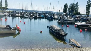 A marina with boats docked, a covered boat, and a wooden dock.