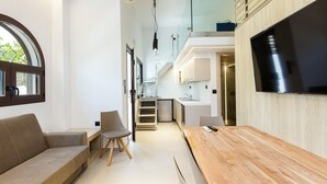 Una cucina moderna con un piano di lavoro in legno, forno integrato e frigorifero in acciaio inossidabile.