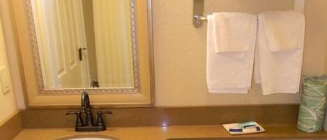 A bathroom with a sink, mirror, and toilet.