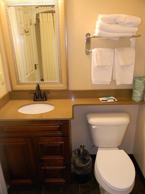 Bañera con ducha, toallas, jabón, shampoo
