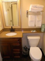 Bañera con ducha, toallas, jabón, shampoo